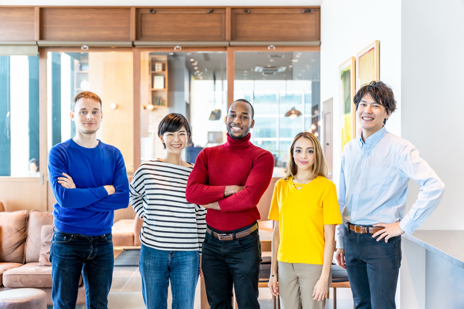 日本人と外国人のスタッフが笑顔で並ぶオフィス